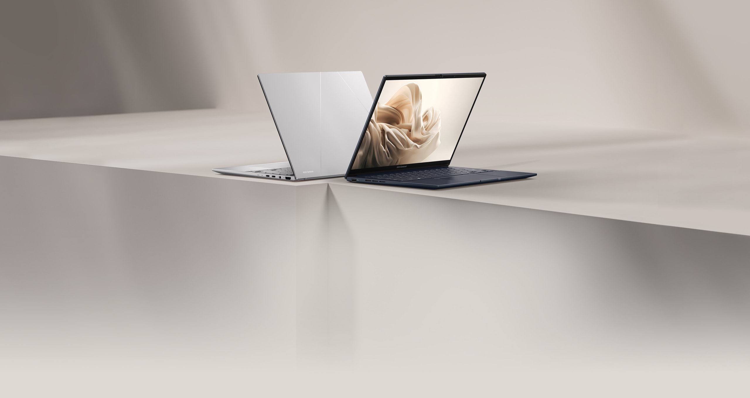 תמונת ASUS הרשמית של סדרת Zenbook 14: מחשב כסוף וכחול על משטח בהיר